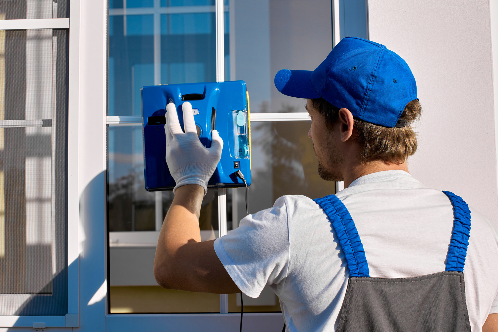 professional cleaning company employee adjusts settings window cleaner robot